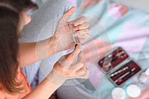 Girl smooths her nails with a manicure file, close-up