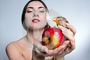 A girl with a snail on the apple