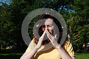 Girl sneezes because of the poplar fluff. Allergic reaction to poplar fluff