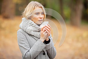 Girl sneezing in tissue. Young woman blowing her nose on the park. Woman portrait outdoor sneezing because cold and flu