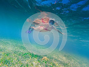 Girl snorkeling in a beautiful lagoon plenty of fish