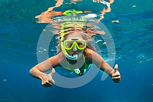 Girl in snorkeling mask dive underwater with coral reef fishes