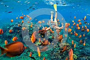 Girl in snorkeling mask dive underwater with coral reef fishes