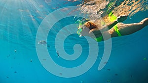 Girl in snorkeling mask dive underwater with coral reef fishes