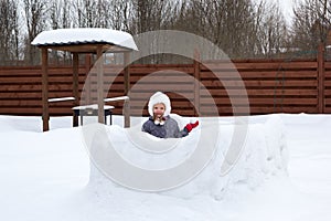 Girl in snow fortress playing snowballs