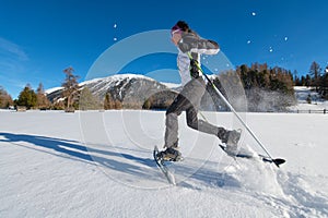 Girl in the snow runs with snowshoes