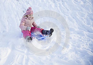 Girl on snow slides in winter time