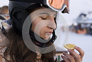 Girl in snowboard helmet holding lemon
