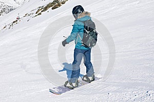 Girl snowboarder on the background of mountains in the winter se