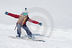 Girl snowboarder goes quickly down the slope and shouts