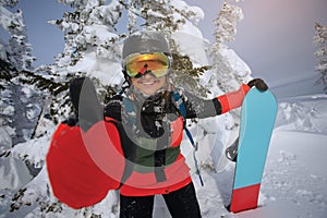 Girl snowboarder shows thumb.