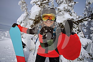 Girl snowboarder shows thumb.