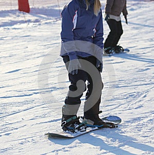 The girl is snowboarding in the snow