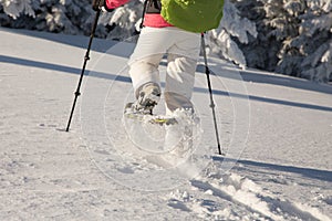 Girl snowshoeing in frozen snow on a cold sunny day