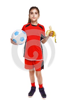 Girl soccer player eating banana as halftime snack