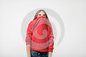 A girl with a social phobia hides her face in a sweater.