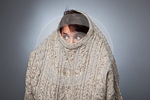 A girl with a social phobia hides her face in a sweater. photo