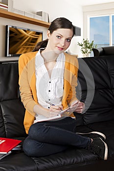 Girl on sofa with laptop, she indicates the displa