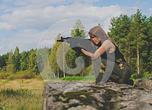 Girl soldiers take aim from the gun being on a hill