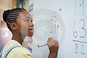 Girl solving mathematical addition photo