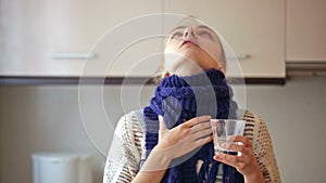 Girl with sore throat gargling in the kitchen