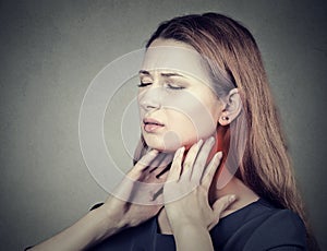 Girl with sore throat neck colored in red. Sick woman having pain in throat photo