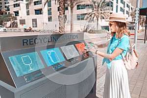 Girl sorts and throws garbage in a street station for recycling plastic waste. Environment conservation concept