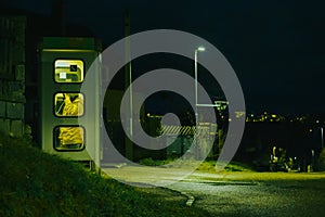 girl speaks in the night telephone booth. mystical and mysterious street phone