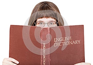 Girl with spectacles looks over English Dictionary