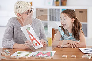 Girl spelling letters with therapist photo