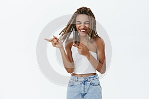 Girl spending time in hilarious company. Joyful attractive and carefree charming dark-skinned female with dreads