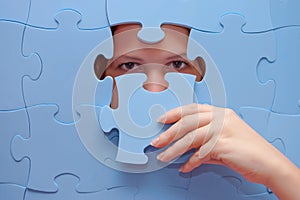 Girl spies through a blue puzzle