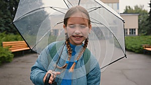 Girl spinning holding umbrella smiling laugh child holiday weekend schoolgirl rain weather springtime outside park city