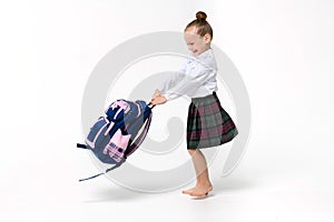 Girl spinning with a huge school backpack on a white background