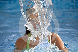 Girl splashing water in the swimming pool