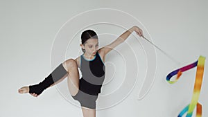 Girl in sport clothes makes motion with ribbon