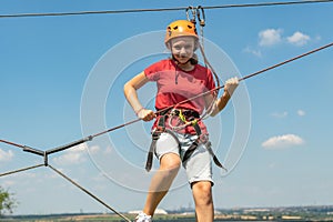 A girl in a sports park on a cable car overcomes obstacles photo