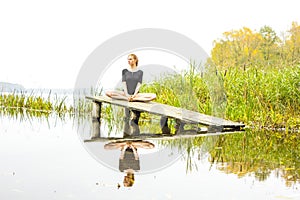 Girl with sports figure on background of calm autumn river. Yoga, Meditation, Relax