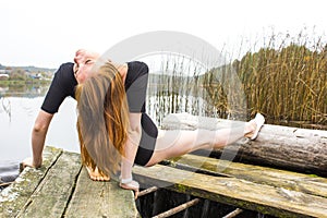 Girl with sports figure on background of calm autumn river. Yoga, Meditation, Relax