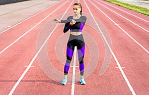 Girl sportsman crossfit and squats agains on stadium