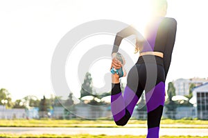 Girl sportsman crossfit and squats agains at sunset in the stadium