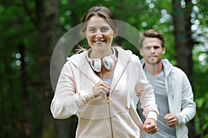 girl in sportswear on run in forest