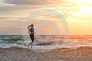 Girl in sportswear running along the surf line. Early morning