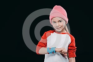 Girl in sportswear with sweatband and fitness tracker isolated on black