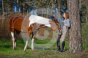 Girl sportswoman and her horse in the spring