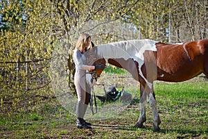 Girl sportswoman and her horse in the spring