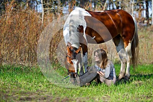 Girl sportswoman and her horse in the spring