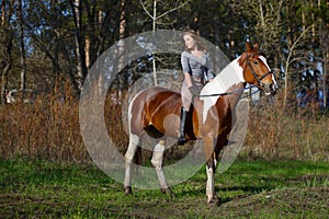 Girl sportswoman and her horse in the spring