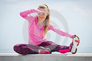 Girl in sporty clothes exercising and looking into distance by the sea, healthy active lifestyle