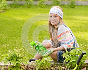 Girl sprays plants in the garden photo